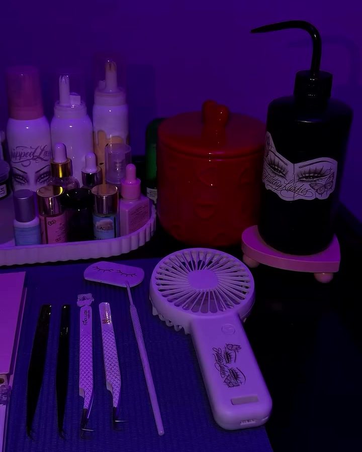 Lash station under purple light with tweezers, a lash fan and VEYES trays